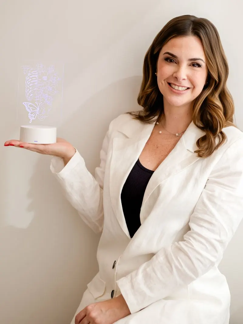 Dra. Bibiana Manna segurando uma luminária com o desenho da caixa torácica e flores